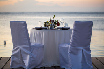 Romantic dinner setting on the beach at sunset