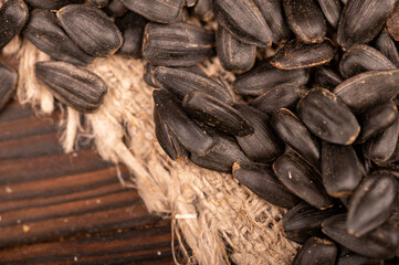 Fried black sunflower seeds scattered on the table, close-up, selective focus.