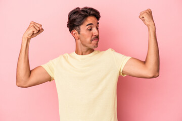 Young mixed race man isolated on white background showing strength gesture with arms, symbol of feminine power