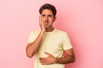 Young mixed race man isolated on white background blows cheeks, has tired expression. Facial...