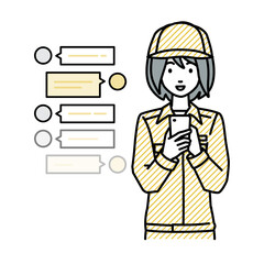 立ってスマートフォンで楽しくチャットで会話する作業員の女性