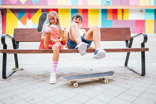 Playful friends sitting on bench