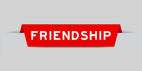 Red color inserted label with word friendship on gray background