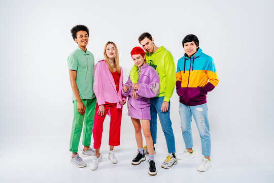 Smiling young men and women in colorful clothes standing on white background