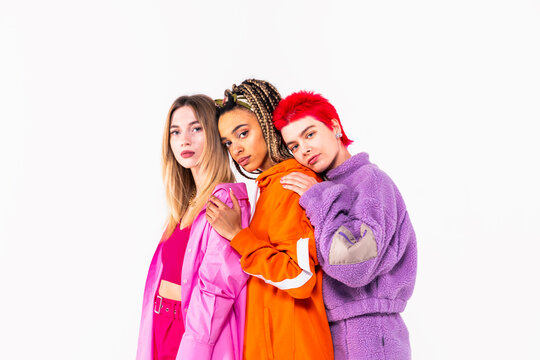 Young female friends staring while standing over white background