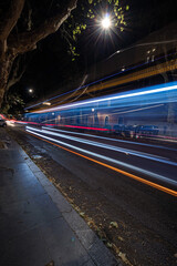 long exposure bus traffic neon blue-orange light trails, night view