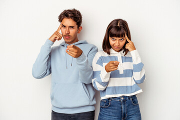 Young mixed race couple isolated on white background pointing temple with finger, thinking, focused on a task.