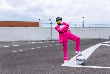 Funny character wearing animal mask and pink business suit having fun on empty parking lot