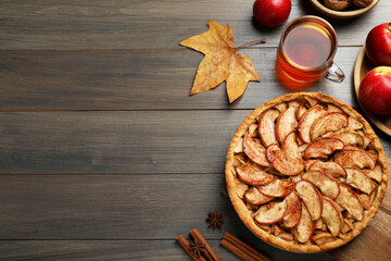 Fototapeta na wymiar Delicious apple pie, ingredients and cup of tea on wooden table, flat lay. Space for text