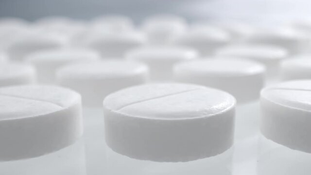 Macro shot of medications tablets drugs on a white soft background. Treatment pharmacology oncept.