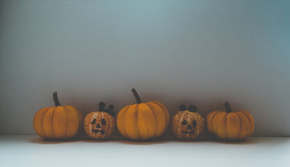 Halloween food background containing orange pumpkins and tangerines