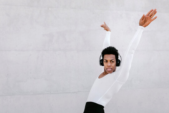 Male Dancer Looking Away While Doing Urban Dance Against White Wall