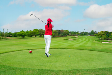 woman Golfer Hitting Ball with Club on Beatuiful Golf Course