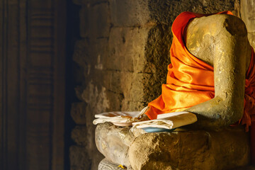 Buddha head broken Sitting in Angkor Wat temple, Siem Reap Cambodia