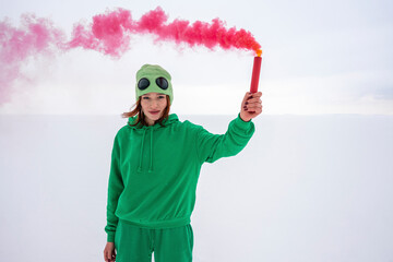 Woman holding red smoke distress flare against sky
