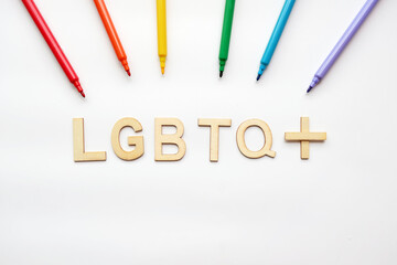 Flatlay wood text LGBTQ+ with colorful marker pen on clear background.for LGBTQ+ concept.