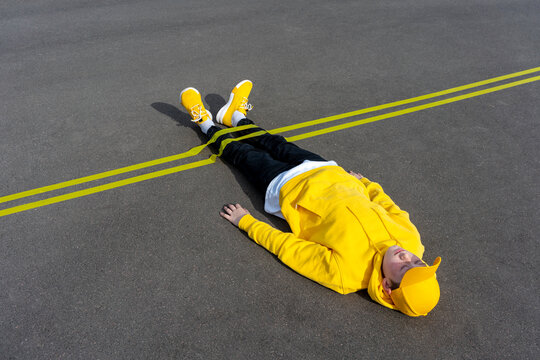 Yellow marking over boy's leg lying on road