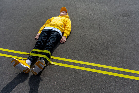 Yellow adhesive tape marking over boy lying on road