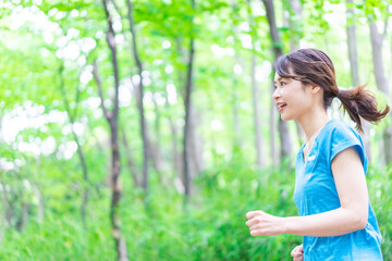 自然の中でランニングをする若い女性
