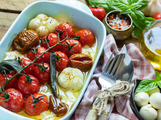 Baked vegetable tomato, basil, mozzarella cheese, garlic in the oven in ceramic dishes. cooking, cooked dish close-up
