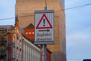 Traffic sign with text wait for passing train at City of Z&uuml;rich on an autumn evening. Photo taken September 22nd, 2021, Zurich, Switzerland.