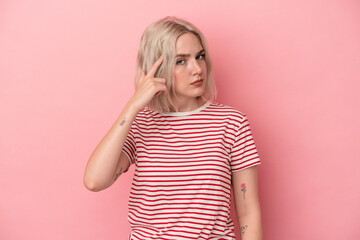 Young caucasian woman isolated on pink background pointing temple with finger, thinking, focused on a task.