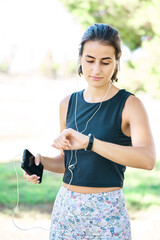 Female athlete controls her heart rate with technology before running. Motivation health and fitness.