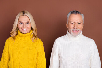 Photo of optimistic couple blond elder lady grey hairdo beard man wear yellow white sweater isolated on brown color background