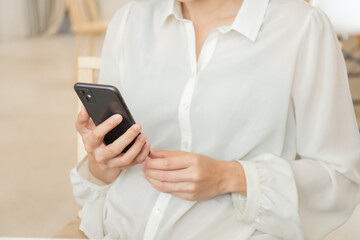 using cell phone hand holding mobile texting message contact us.chatting,search internet information in office.technology device communication connecting