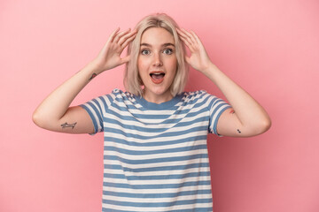 Young caucasian woman isolated on pink background receiving a pleasant surprise, excited and raising hands.