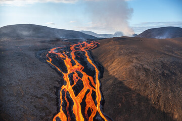 Volcanic eruption. Fresh hot lava, flames and poisonous gases going out from the crater.