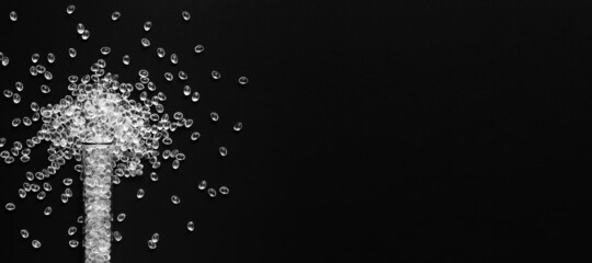 White granules of rubber, polypropylene or polyamide on a black background with tube. 