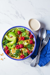 Green broccoli salad with raspberries, pine nuts and avocado. Vegan food concept.