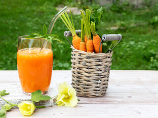 Fresh squeezed carrot juice in a glass on a wooden surface, rustic style  Healthy eating, detox, dieting and vegetarian concept.