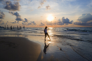 young asia woman walking seaside and rest on tropical Beach on sunset time or sunrise time