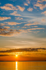 Sunset over the sea. Reflection of sunlight in the sea waves. The sky in the sunset rays.