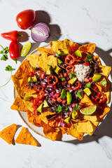 Mexican food concept. Corn nachos chips with avocado, pepper, salsa and grilled minced beef on...