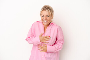Young Russian woman isolated on white background laughs happily and has fun keeping hands on...
