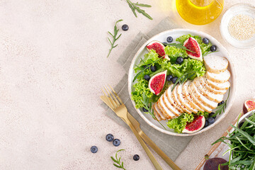 Chicken breast baked and fresh salad of lettuce, arugula, blueberry and figs. Healthy diet food....