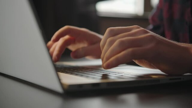 Laptop typing, male hands keyboard. Office work in the evening. Close-up, no face in the frame. Programming, information analysis. The student is studying, writing a project. Desktop, space for work.