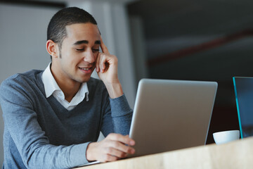 Young man reading or watching media on a laptop computer