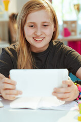 school girl having distance education at home in sunny day