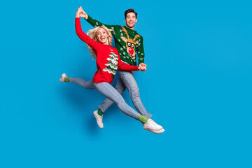 Full length body size photo couple jumping up holding hands dancing on xmas isolated pastel blue color background