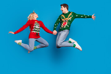 Plakat Full length photo of impressed young couple jump wear sweater jeans socks shoes isolated on blue background