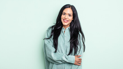 pretty hispanic woman laughing shyly and cheerfully, with a friendly and positive but insecure...