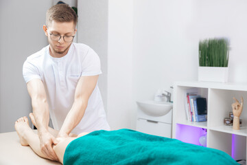 Obraz na płótnie Canvas Closeup hand of therapist osteopathy working sports massage with knees legs of woman