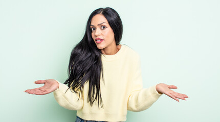 pretty hispanic woman feeling clueless and confused, having no idea, absolutely puzzled with a dumb...