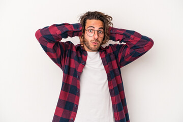 Young caucasian man isolated on white background covering ears with hands trying not to hear too loud sound.