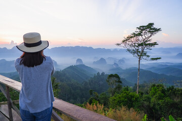 Fototapeta na wymiar young asia woman feeling happy wearing hat resting on tropical mountain at Doi Ta Pang (khao thalu) travel in chumphon thailand