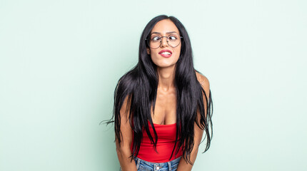 pretty hispanic woman looking goofy and funny with a silly cross-eyed expression, joking and...